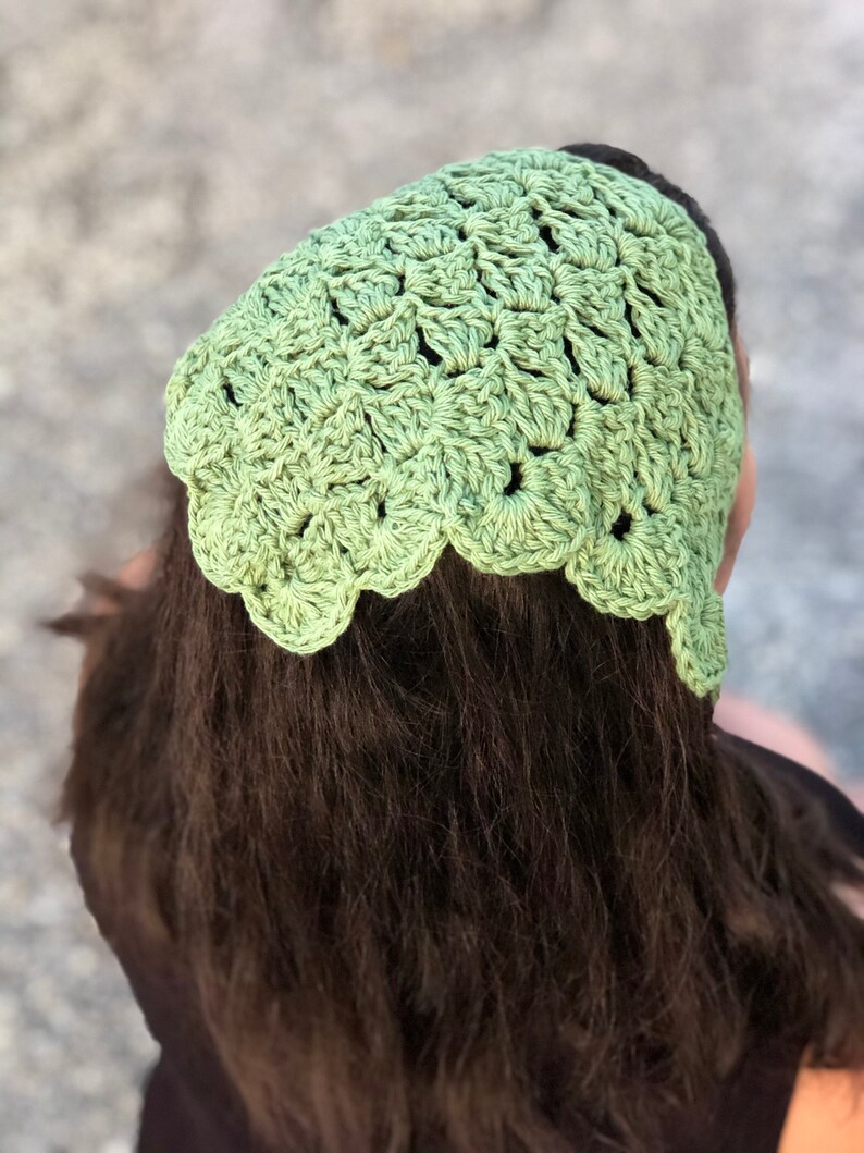 Puede incluir: Un cubrecabezas de ganchillo verde claro con un borde festoneado. El cubrecabezas est&aacute; hecho de un hilo texturizado y se usa en la cabeza. El cubrecabezas es un accesorio elegante.