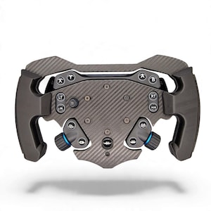 May include: A carbon fibre racing steering wheel controller featuring a central plate with a woven texture, black rubberised grips, and various buttons labelled X, Y, A, B, LT, RT, LSB, RSB, GL, GR, and G1, along with two blue-accented rotary dials.