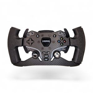 以下が含まれることがあります： 黒とグレーのMOZAレーシングホイール。テクスチャード加工されたグリップと複数のボタンが付いています。カーボンファイバーのデザインで、さまざまなコントロールボタンと中央のロゴが付いています。ゲーム用に設計されたホイールです。