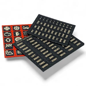 May include: Three black and red racing control panel stickers with white text. The stickers include labels for various car functions like "BOOST", "TYRES", and "TURBO". The red sticker has icons.