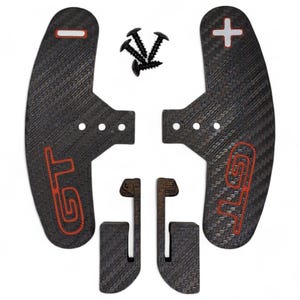 May include: A set of black carbon fiber paddle shifters with red "GT" lettering and a plus and minus symbol. Includes black screws and two additional pieces. The shifters are designed for automotive use.