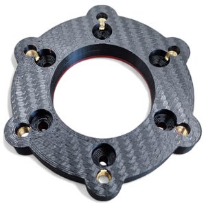 May include: A circular, black carbon fiber component with six threaded brass inserts. The component has a textured surface and a red inner ring. The design includes three rounded protrusions evenly spaced around the outer edge.