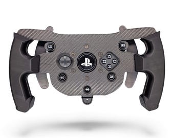 May include: A black carbon fiber racing steering wheel controller featuring a central PlayStation logo, directional pad, four action buttons, and L1, R1, L2, R2 shoulder buttons. The device has ergonomic side grips and metal paddle shifters.