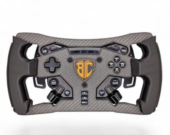 May include: A grey carbon fiber textured racing steering wheel controller featuring a central shield emblem with the letters BC in orange. The device includes a directional pad, four action buttons labeled A, B, X, Y, and various toggle switches.