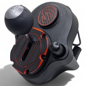May include: Black and red racing simulator shifter with a carbon fiber design. The shifter features a black leather-wrapped shift knob with a silver top, and a red and black accent design. The device has a button and a logo.