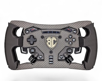 May include: A dark gray carbon fiber textured racing steering wheel controller featuring a central shield logo with the letters BC, a directional pad, four action buttons labeled A, B, X, Y, multiple circular control knobs, and small toggle switches.