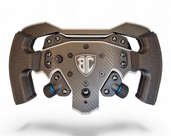May include: A black carbon fiber racing steering wheel controller featuring a central shield logo with the letters BC. The device includes various buttons labeled A, B, X, Y, LT, RT, LSB, RSB, and other icons, along with two blue-accented rotary dials.