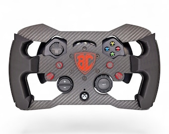 May include: A black carbon fiber racing steering wheel controller featuring a central red shield logo with the letters BC. The device includes a D-pad, colored action buttons, a circular dial, a plus-minus button, and a central Xbox logo button.
