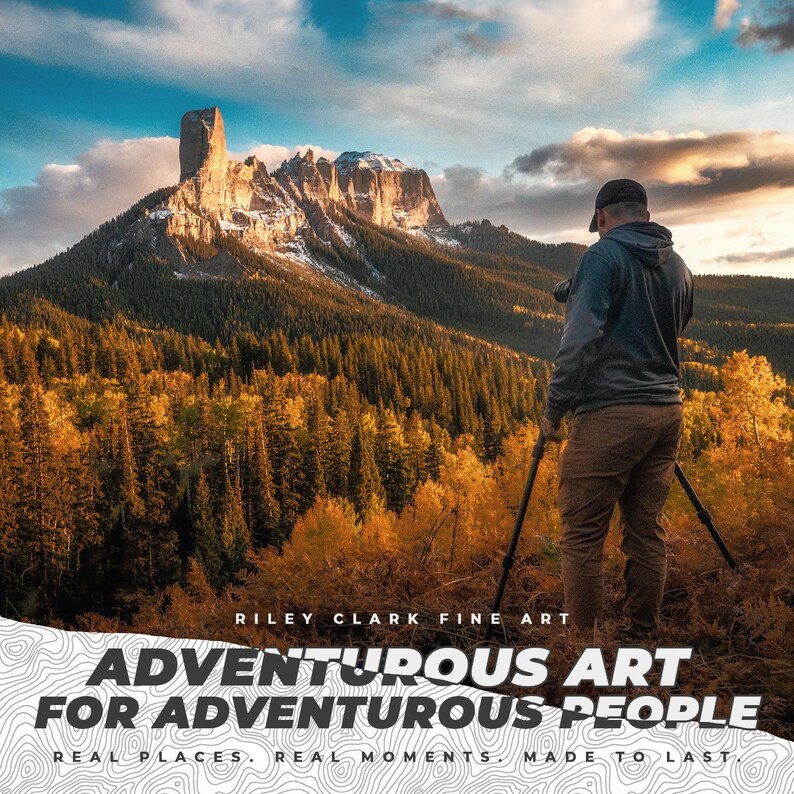 May include: A landscape photograph of a mountain with a flat top and snow-covered peaks. A person is seen with a camera on a tripod, taking a picture. The image includes text that reads "ADVENTUROUS ART FOR ADVENTUROUS PEOPLE."