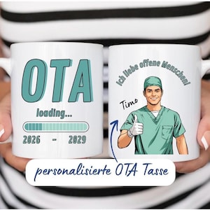 Könnte beinhalten: Zwei weiße Keramiktassen. Eine Tasse zeigt den Text OTA loading... mit einem Ladebalken und den Jahren 2026 - 2029. Die andere Tasse zeigt eine Illustration einer Person in grüner OP-Kleidung mit erhobenem Daumen, dem Namen Timo und dem Text Ich liebe offene Menschen!