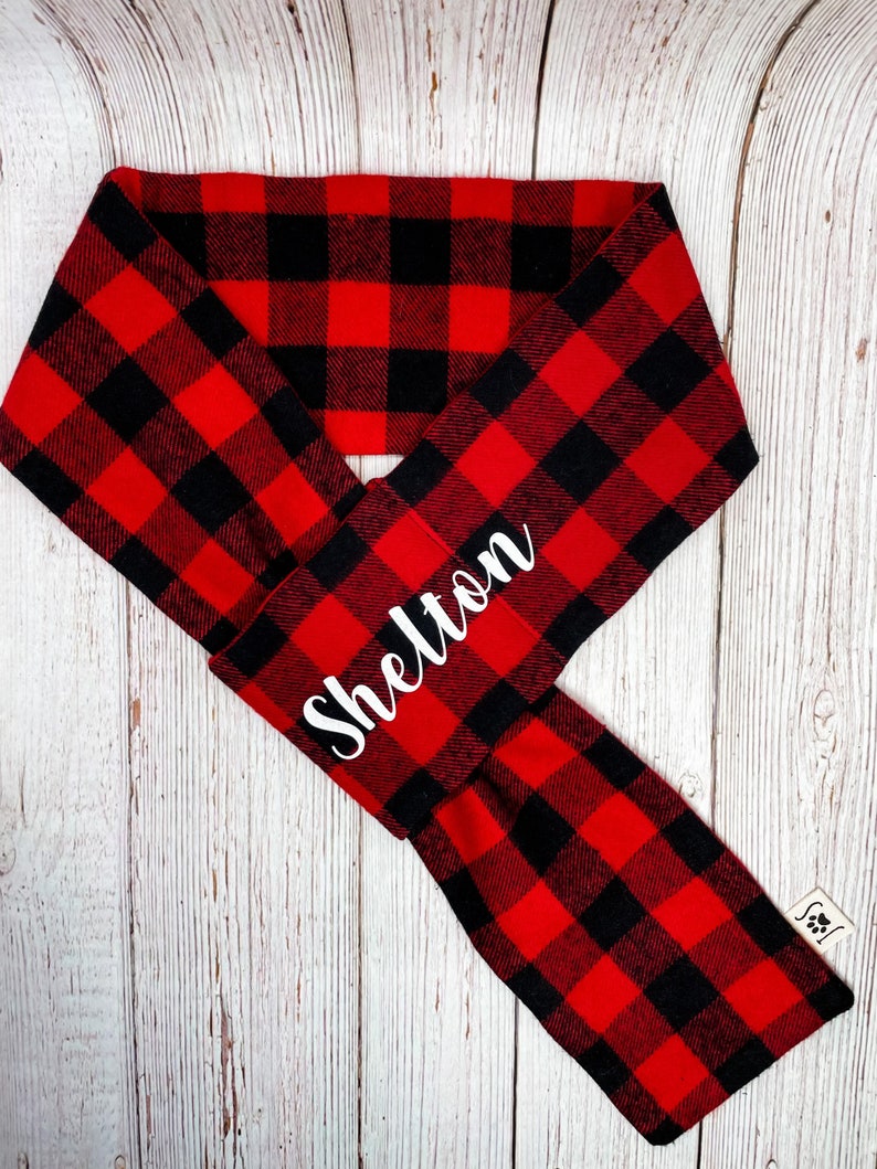 May include: Red and black buffalo plaid dog bandana with the name "Shelton" embroidered in white.