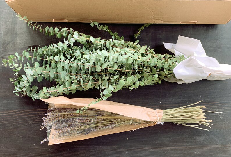 May include: Two bundles of dried flowers, one bundle of eucalyptus in white paper and one bundle of lavender in brown paper.