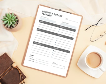 May include: A monthly budget planner on a clipboard with sections for income, bills, other expenses, savings, and a total. The planner has a gray background and white text.
