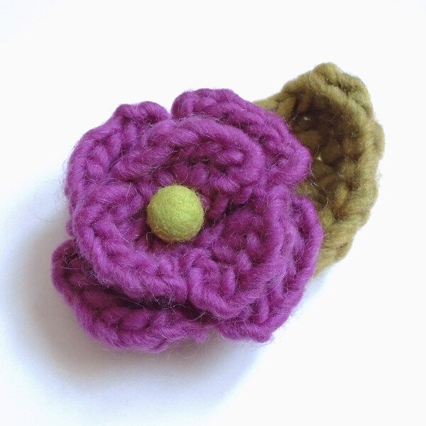 Crocheted flower pin, chunky pinkish purple yarn, yellow-green felted ball for center, yellow-green chunky yarn leaf