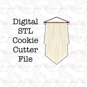 Peut inclure: Fichier de découpe de cookie STL numérique pour une suspension murale en macramé. Le motif est une suspension murale en macramé blanche avec une baguette en bois brun en haut.