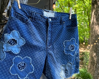 Denim on denim flower-patched cut off shorts; Boho style size 14 hi-waist jeans shorts; Hippie-style patched and hand-stitched shorts.