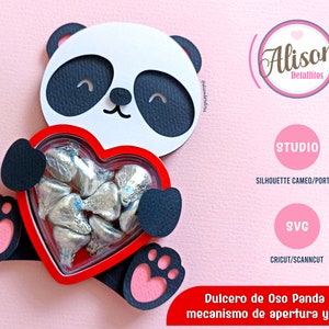 May include: A red heart-shaped candy box with a panda bear design. The box has a hinged lid and a mechanism for opening and closing. The panda bear is black and white with a cute expression. The box is filled with silver foil-wrapped chocolates.