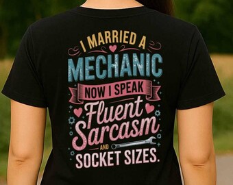 Puede incluir: Camiseta negra con un gráfico blanco que dice "Me casé con un mecánico ahora hablo sarcasmo fluido y tamaños de zócalos."