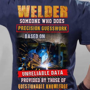 May include: Navy blue t-shirt with the text "WELDER" in distressed orange lettering. The shirt features a graphic of a welder at work, with text that reads "SOMEONE WHO DOES PRECISION GUESSWORK BASED ON UNRELIABLE DATA PROVIDED BY THOSE OF QUESTIONABLE KNOWLEDGE."