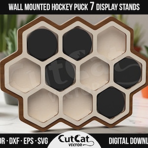 May include: A wall-mounted hockey puck display stand with a honeycomb design. The stand is made of wood and features seven hexagonal compartments, some holding black hockey pucks. The text "WALL MOUNTED HOCKEY PUCK 7 DISPLAY STANDS" is at the top.