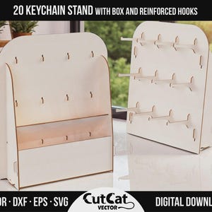 Può includere: Due espositori per portachiavi in legno bianco con ganci rinforzati e una scatola. Gli espositori hanno una parte superiore arrotondata e sono progettati per contenere 20 portachiavi. Il testo "20 KEYCHAIN STAND WITH BOX AND REINFORCED HOOKS" è in alto.
