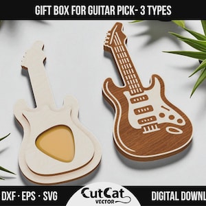 Puede incluir: Dos cajas de regalo de madera con forma de guitarra para púas. Una es de color claro con un recorte para una púa, la otra es marrón con detalles blancos. El texto "GIFT BOX FOR GUITAR PICK - 3 TYPES" está en la parte superior.