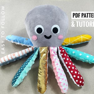 May include: A soft octopus toy with a grey body, smiling face, and colourful tentacles. The tentacles feature star, polka dot, and geometric patterns in various colours. The text "PDF PATTERN & TUTORIAL" is visible.