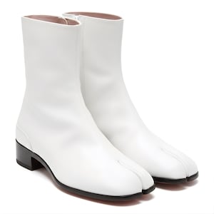 May include: A pair of white leather ankle boots with a unique split-toe design. The boots have a mid-height heel, a side zipper, and a smooth, clean finish. The soles and heels are black.