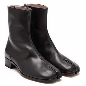 May include: A pair of black leather ankle boots. The boots have a unique split-toe design, a low block heel, and a zipper closure on the inner side. The interior lining is a light pink color. The boots are a sleek and modern style.