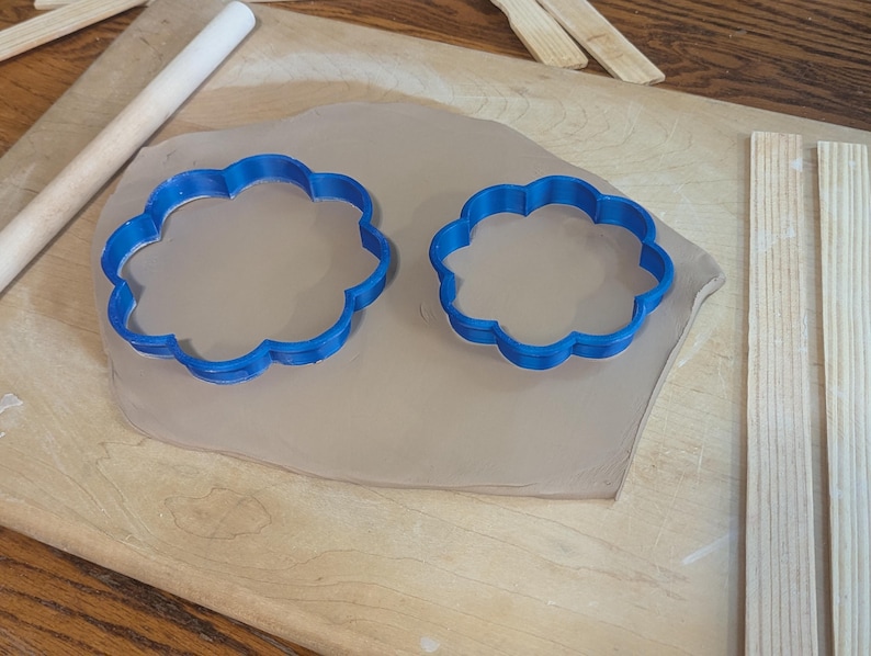 Pottery clay cutter in the shape of a circle with scalloped edges. There is an example project of a flower shaped trinket dish made from the cutter.