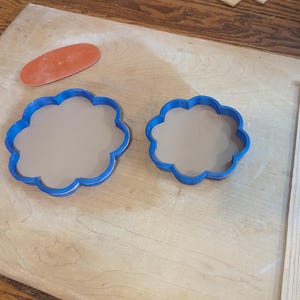 Pottery clay cutter in the shape of a circle with scalloped edges. There is an example project of a flower shaped trinket dish made from the cutter.