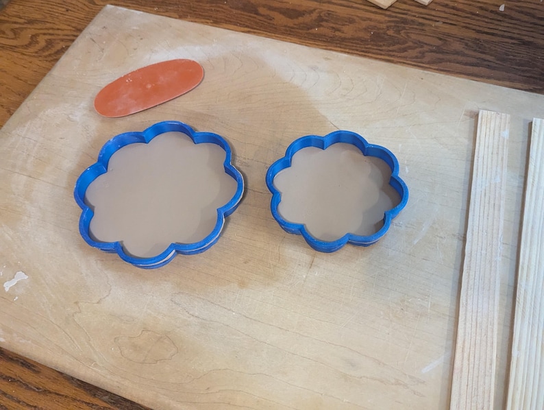 Pottery clay cutter in the shape of a circle with scalloped edges. There is an example project of a flower shaped trinket dish made from the cutter.