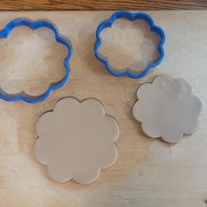 Pottery clay cutter in the shape of a circle with scalloped edges. There is an example project of a flower shaped trinket dish made from the cutter.