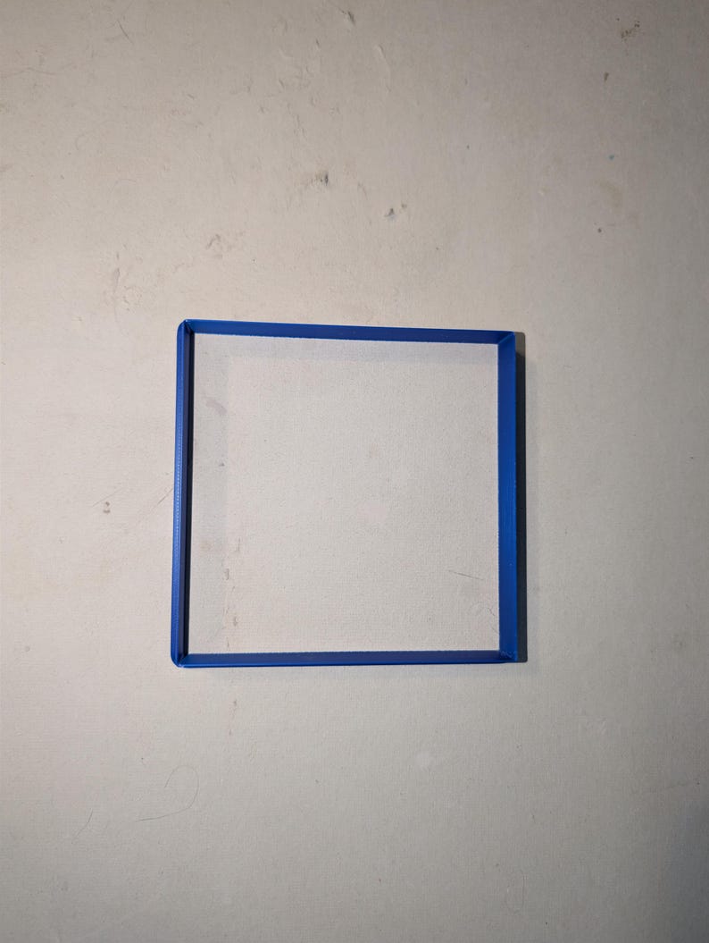 May include: A square, white canvas with a bright blue frame. The frame is a solid, vibrant blue, creating a defined border around the canvas. The canvas is centered, and the background is a neutral, off-white color.