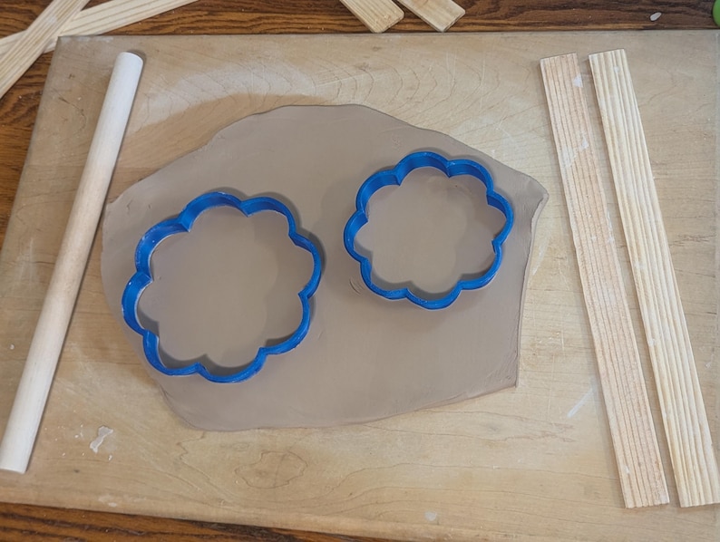 Pottery clay cutter in the shape of a circle with scalloped edges. There is an example project of a flower shaped trinket dish made from the cutter.