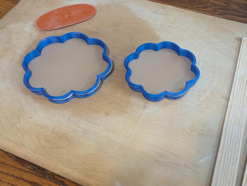 Pottery clay cutter in the shape of a circle with scalloped edges. There is an example project of a flower shaped trinket dish made from the cutter.