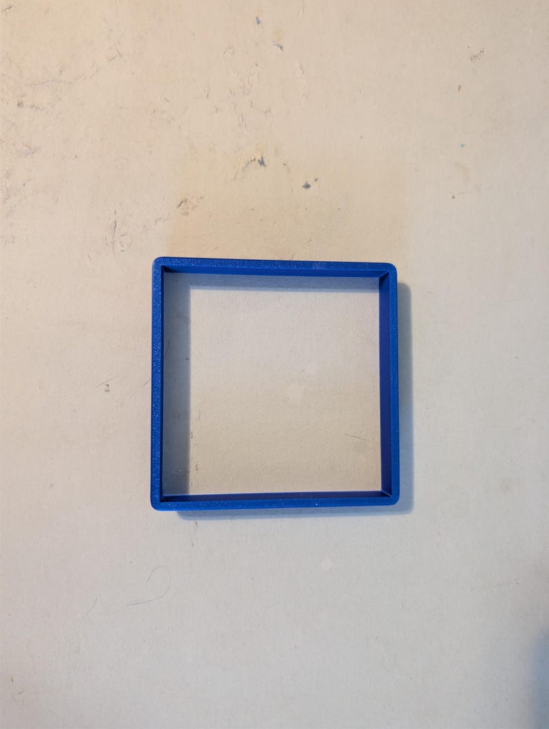 May include: A bright blue square-shaped cookie cutter. The cutter is made of plastic and has a simple, clean design. The square shape is perfect for creating uniform cookies or other baked goods.