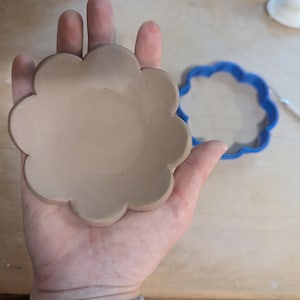 Pottery clay cutter in the shape of a circle with scalloped edges. There is an example project of a flower shaped trinket dish made from the cutter.