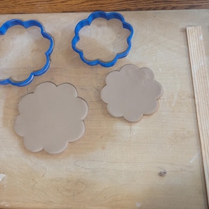 Pottery clay cutter in the shape of a circle with scalloped edges. There is an example project of a flower shaped trinket dish made from the cutter.