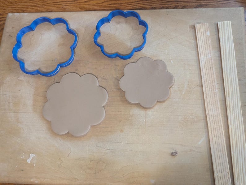 Pottery clay cutter in the shape of a circle with scalloped edges. There is an example project of a flower shaped trinket dish made from the cutter.