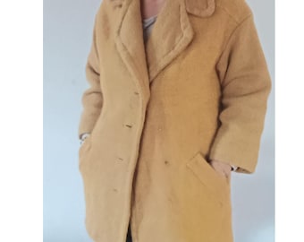 May include: Mustard-colored wool coat with a classic lapel collar, three buttons, and two front pockets. The coat has a textured appearance and a mid-length cut, suitable for cooler weather. A timeless outerwear piece.