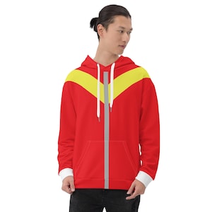Puede incluir: Sudadera con capucha roja con un diseño de chevron amarillo y gris. La sudadera tiene una cremallera y un bolsillo canguro.