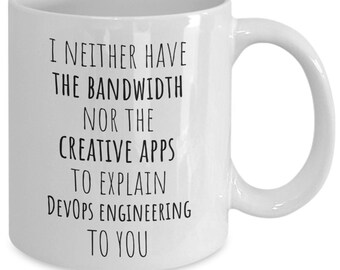 May include: White ceramic coffee mug with black text that reads "I neither have the bandwidth nor the creative apps to explain DevOps engineering to you."
