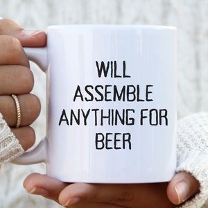May include: White ceramic mug with black text that reads "Will assemble anything for beer".