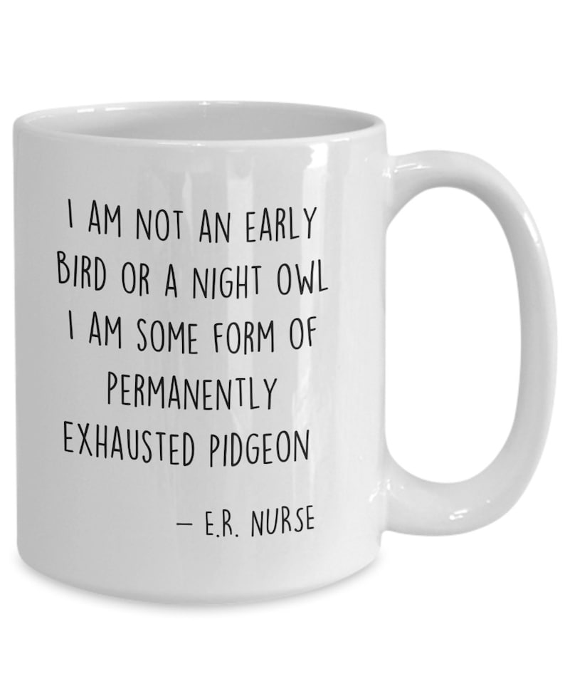 May include: White ceramic coffee mug with black text that reads "I am not an early bird or a night owl. I am some form of permanently exhausted pigeon - E.R. Nurse."