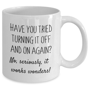 May include: White ceramic coffee mug with black text that reads "Have you tried turning it off and on again? No, seriously, it works wonders!"