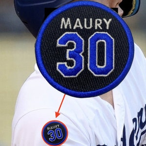 May include: A black and blue embroidered patch with the name "MAURY" and the number "30" in white.