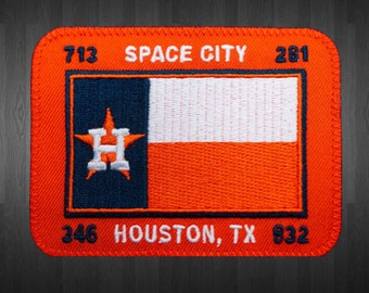 May include: An orange and blue embroidered patch with a Texas flag design. The patch features a white star with a blue "H" inside, surrounded by a blue star. The text "SPACE CITY 713 281" is at the top and "HOUSTON, TX 346 832" is at the bottom.
