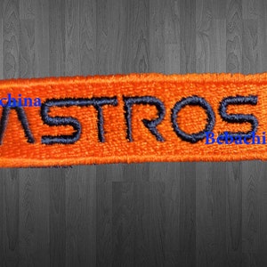 May include: Orange embroidered patch with the word "ASTROS" in navy blue lettering.