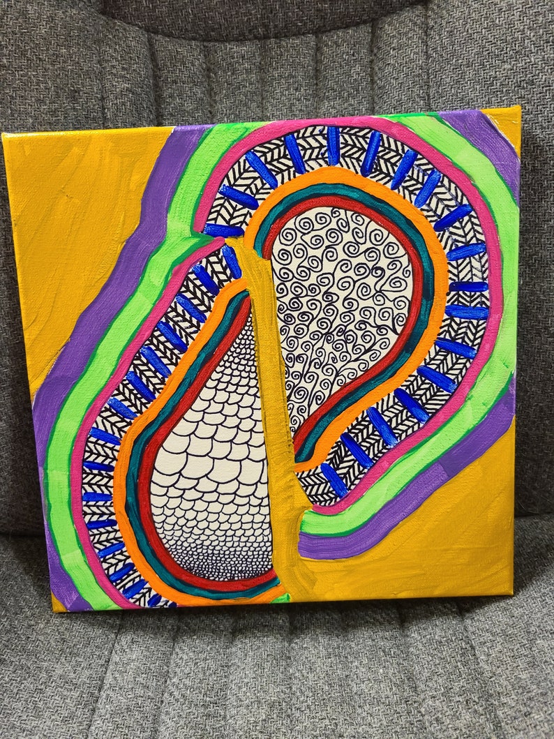 May include: Abstract painting on canvas with a colorful design featuring a large, teardrop-shaped form with a black and white patterned interior. The background is a solid yellow with purple, green, and pink accents.